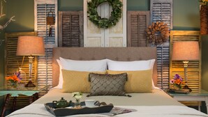A neatly made bed with a tray of breakfast items, two lamps, and decorative wall elements including shutters and a wreath. - 1825 Inn Bed and Breakfast (Palmyra)