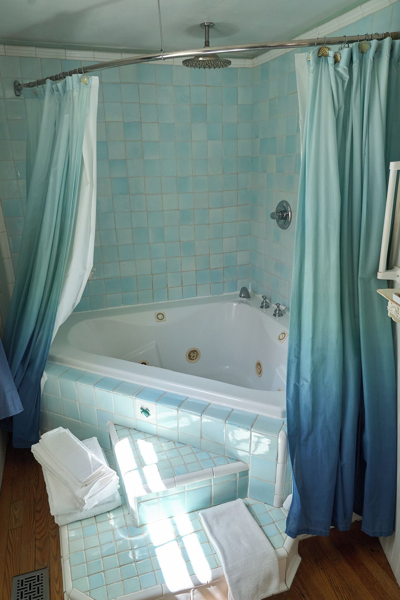 A bathroom with a bathtub, a shower curtain, and a tiled wall.