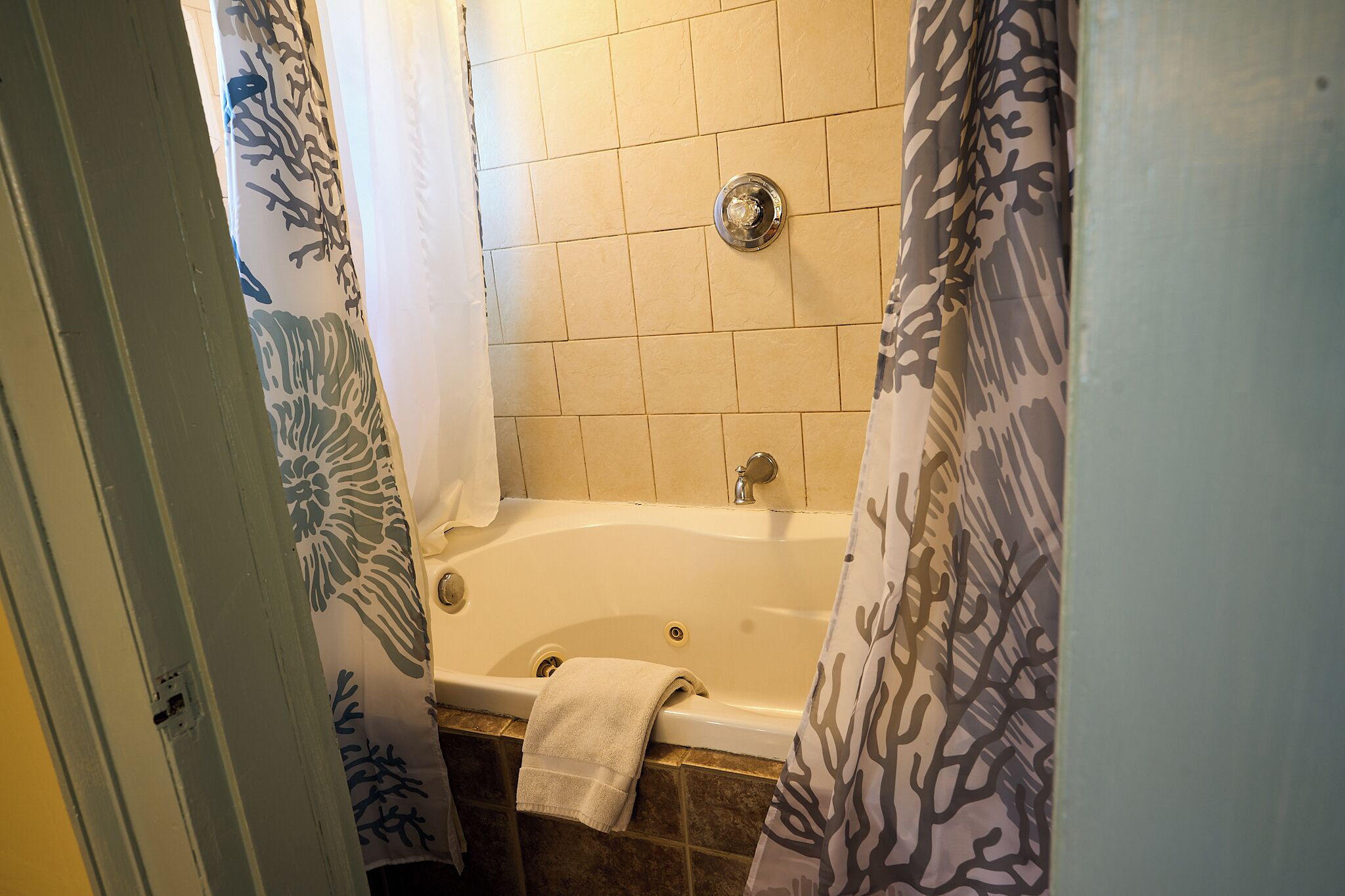 A bathroom with a bathtub, tiled walls, and a shower curtain.