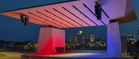 A modern architectural structure with a large overhanging roof and illuminated panels.