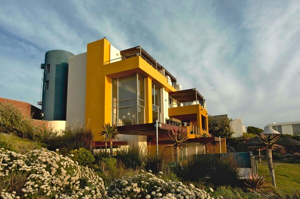 Un edificio moderno de color amarillo con ventanas grandes y una estructura cilíndrica.