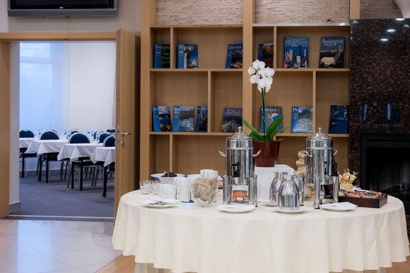 Una preparación para el desayuno con una estación de café, estanterías y vista al comedor.