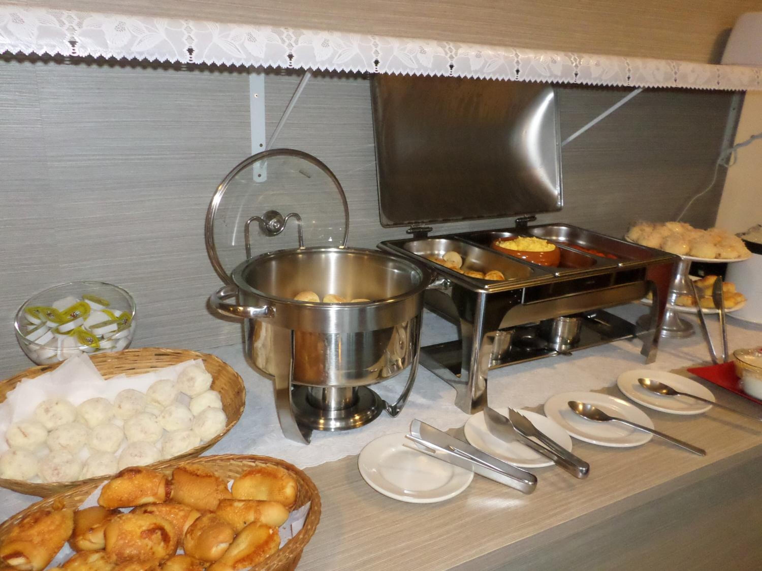 En buffé med ett varierat utbud av mat, inklusive en gryta med soppa, en skål med dumplings och korgar med friterade rätter.