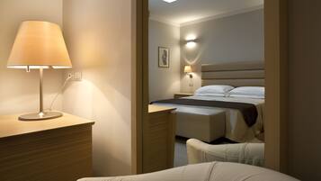 Ein Hotelzimmer mit Bett, Nachttischlampe und Schreibtisch mit Lampe.