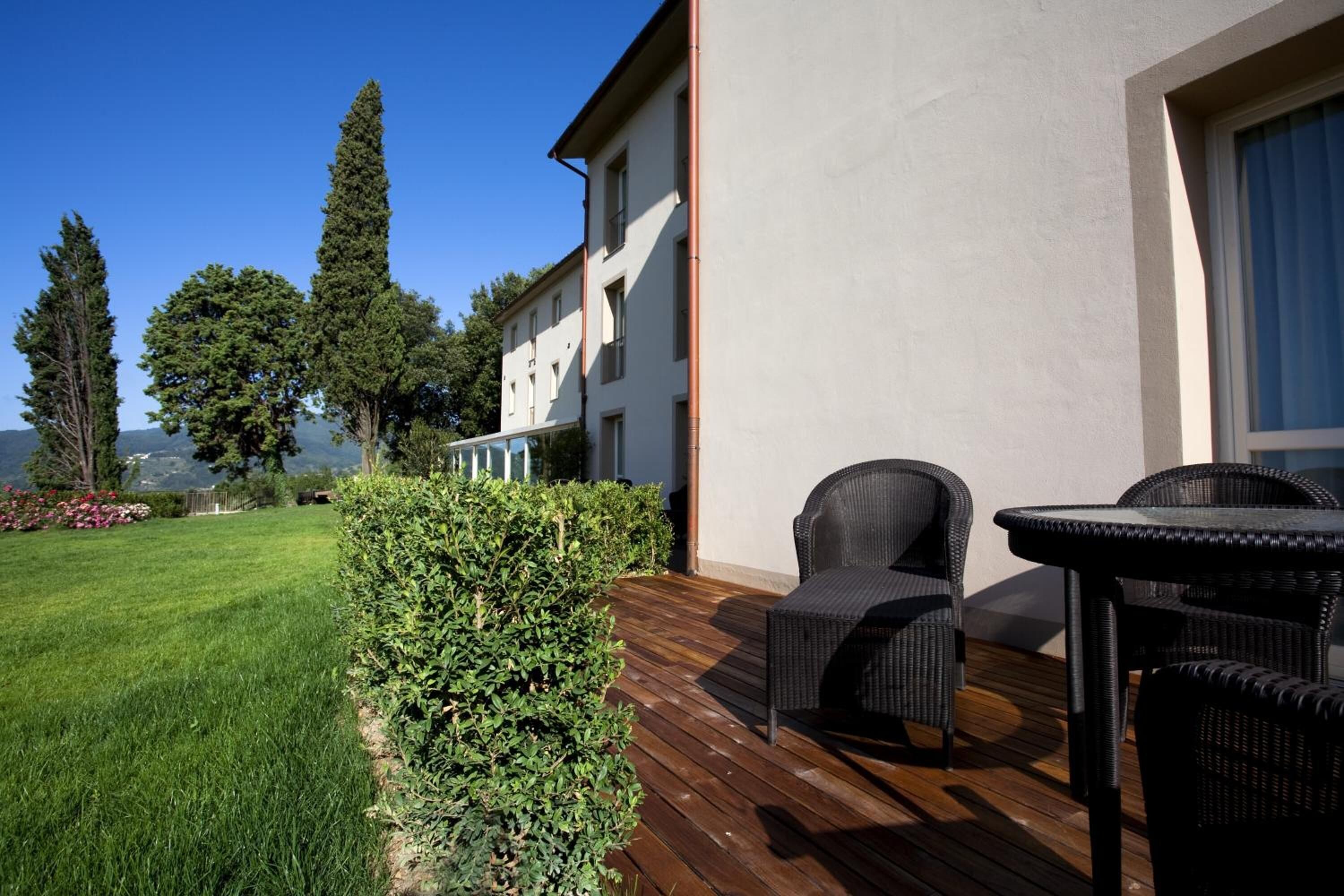 A patio with wicker furniture, a wooden deck, and a view of a mountain.