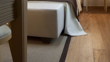 Una habitación de hotel con cama, mesita de noche, lámpara y una silla.