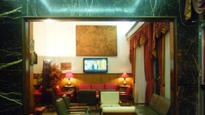 Una habitació amb televisió, zona de seients i un quadre a la paret.