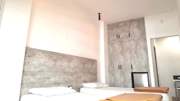 Habitació d'hotel moderna amb un llit gran, un armari i un sistema de calefacció integrat.