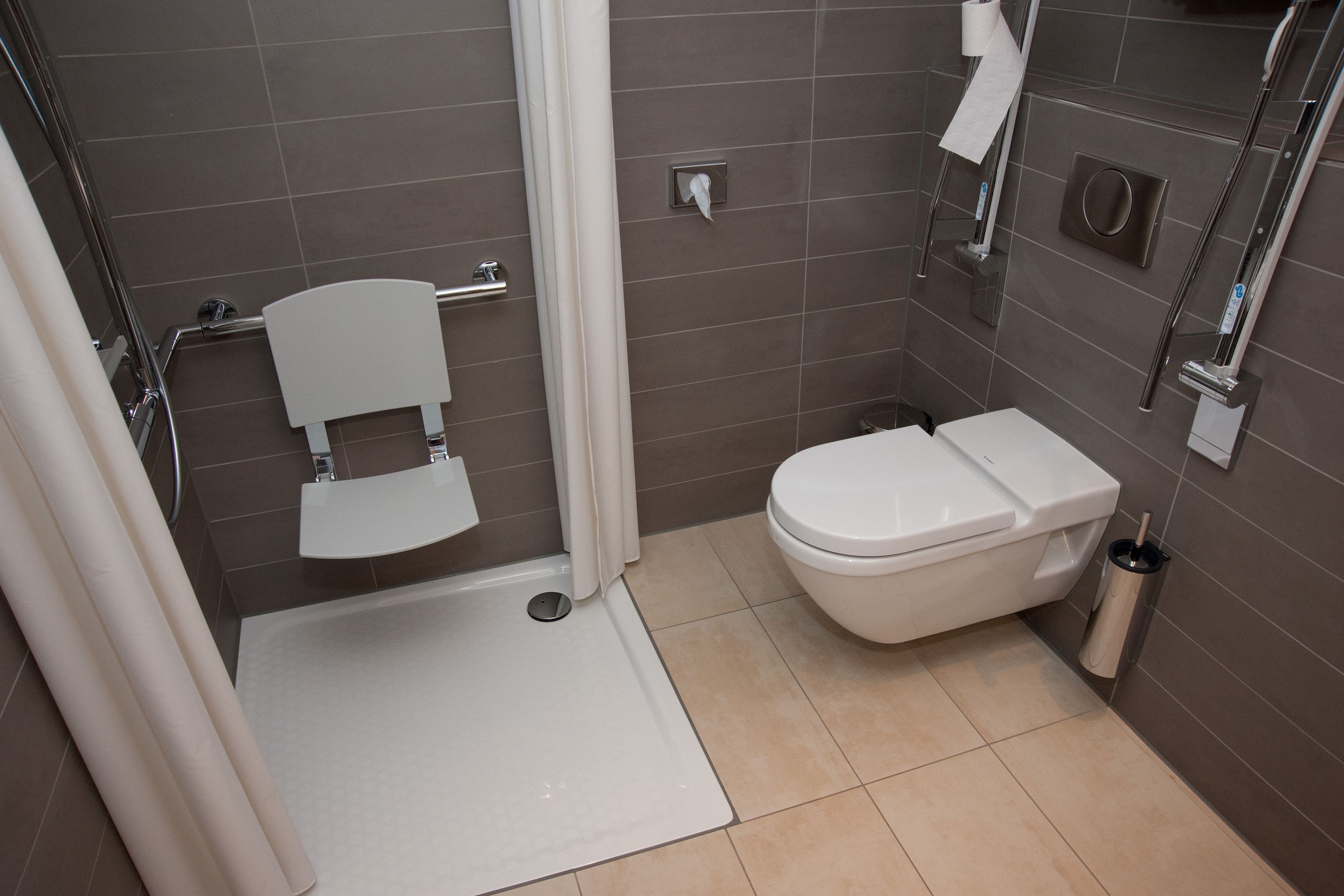 A modern bathroom with a shower, toilet, and sink.