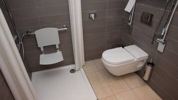 A modern bathroom with a shower, toilet, and sink.