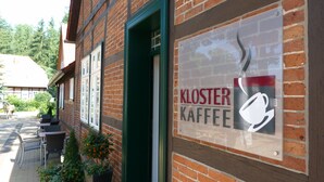 Un edificio de ladrillo con un cartel que dice 'Kloster Kaffee' con una taza de café.