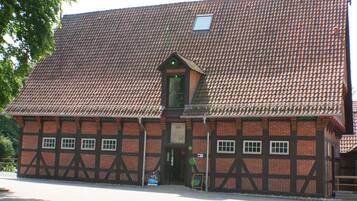 Un edificio tradicional con entramado de madera, techo empinado y una pequeña ventana de tejado.