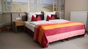 Un dormitorio con cama, mesita de noche y ventana con vista a la playa.