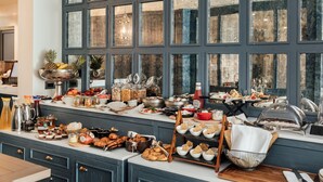 A breakfast buffet with various food items and beverages, set against a backdrop of large windows. - Boutique Hotel Casa del Mare - Mediterraneo (Kamenari)