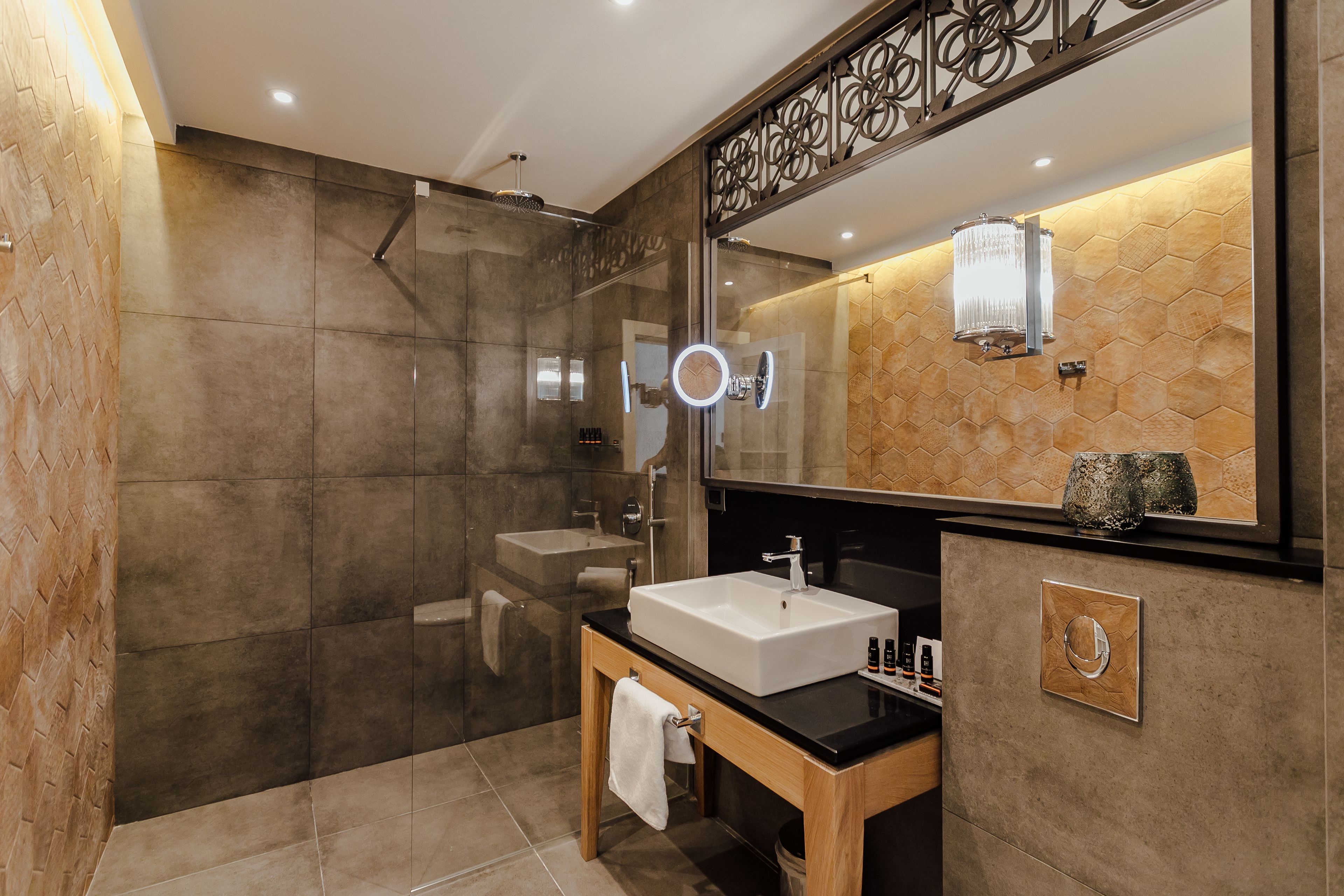 A modern bathroom with a large mirror, a sink, and a shower area.