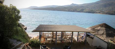 Un patio vista mare con posti a sedere all'aperto e una zona riparata.