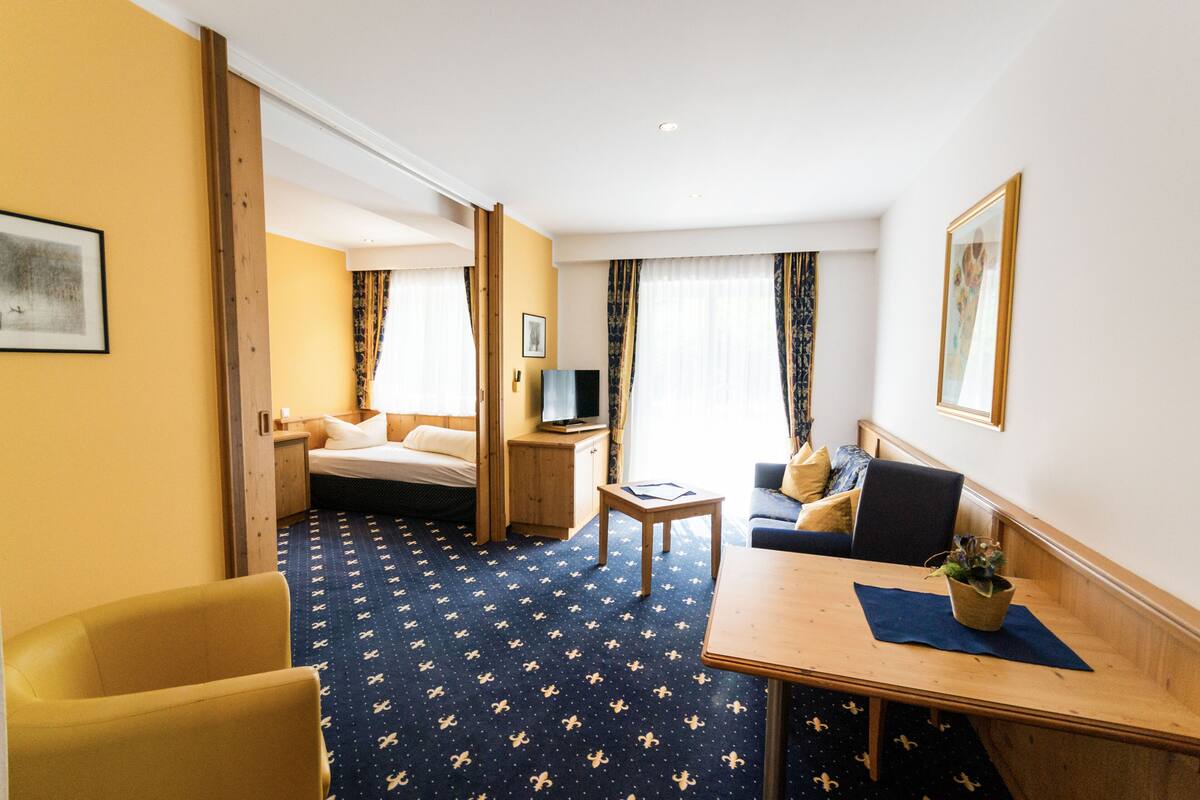 Een hotelkamer met een bed, een bureau, een stoel, een bank en een televisie.
