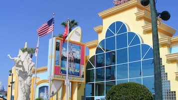 Un edificio con una grande facciata vetrata, un cartello con la scritta "Ron Jon Surf Shop" e una statua di una sirena.