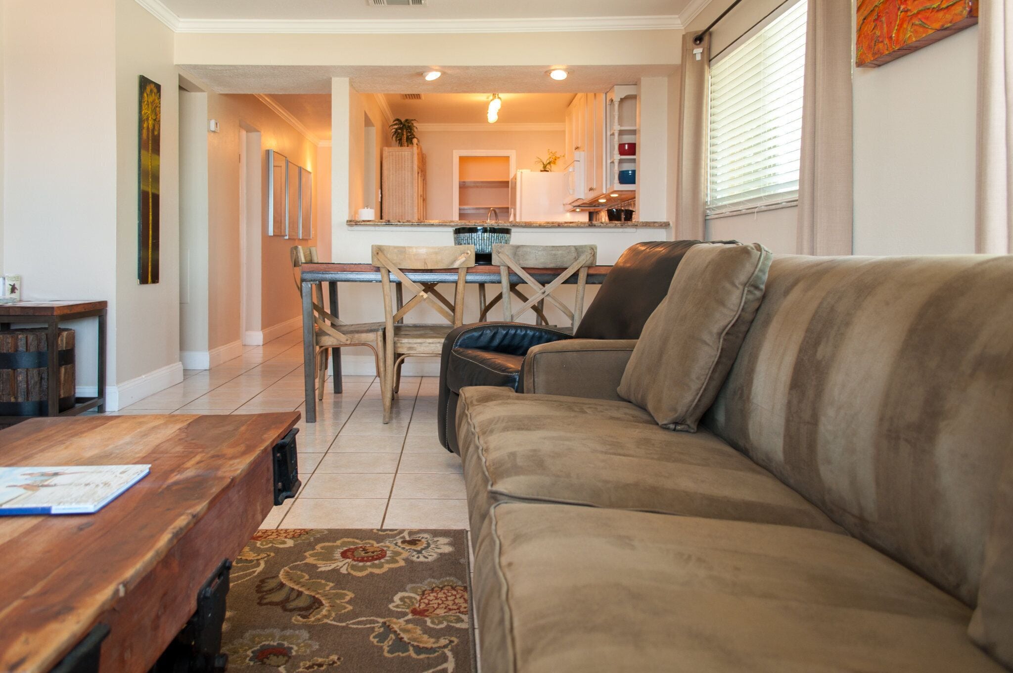 Una sala de estar con un sofá, una mesa de centro de madera y un comedor con sillas y una mesa.