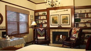Un salon traditionnel avec une cheminée, un coin repas et une bibliothèque.