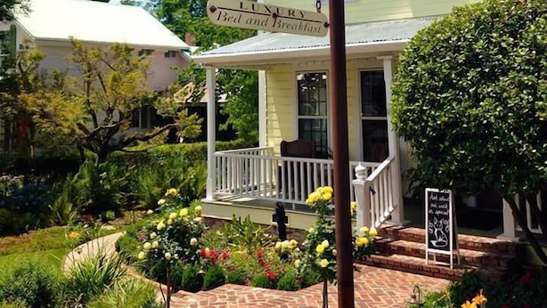 Une enseigne indiquant l’emplacement de The Foxes Inn, un établissement de luxe proposant des chambres et des petits déjeuners, doté d’une véranda et d’un jardin.
