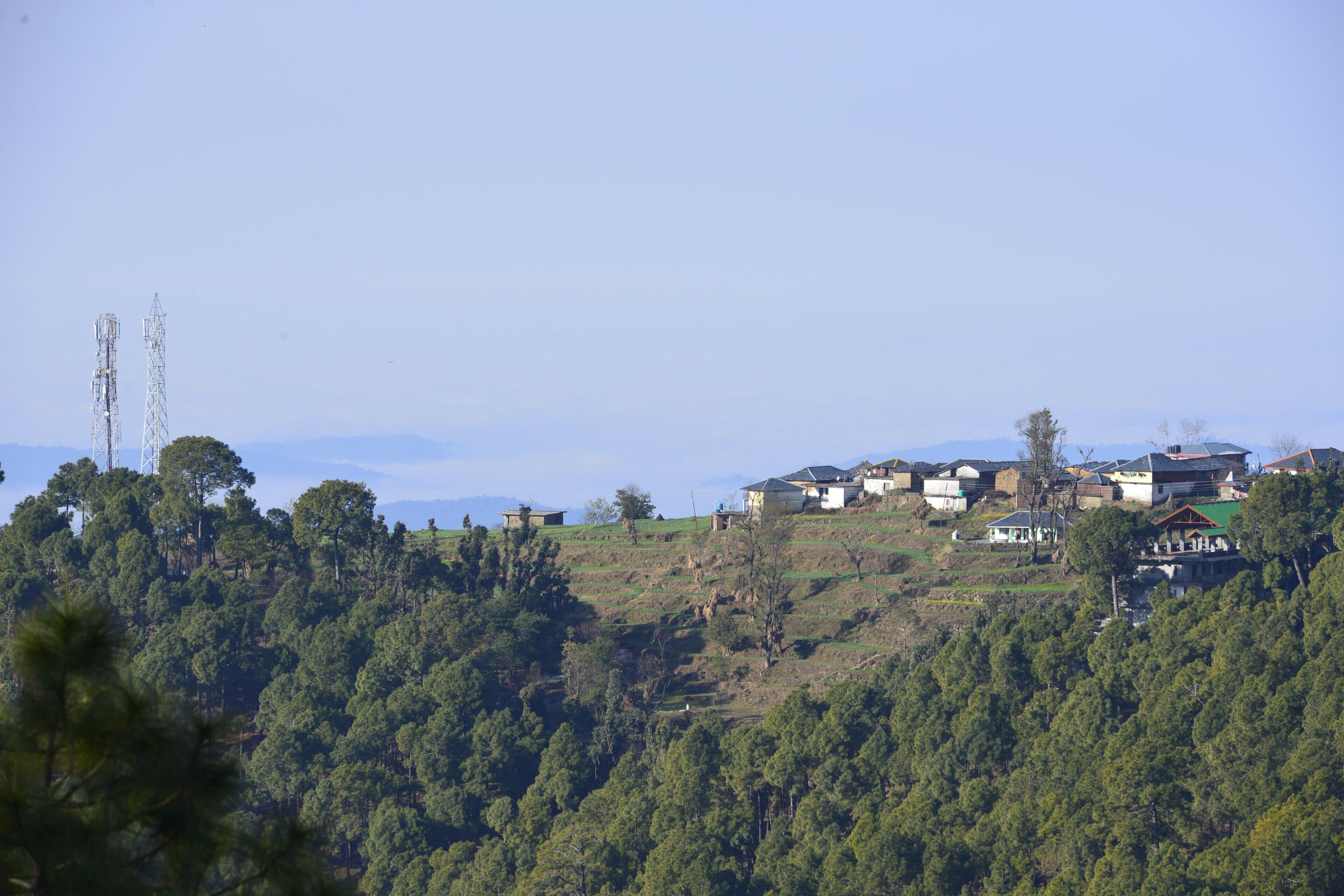 Una zona residencial en una ladera con casas y una torre de telefonía.