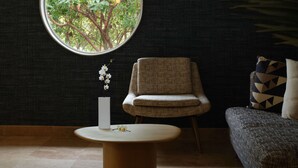 A room with a round window, a chair, a small table, and a sofa. - El Colibri Hotel & Spa (Cambria)