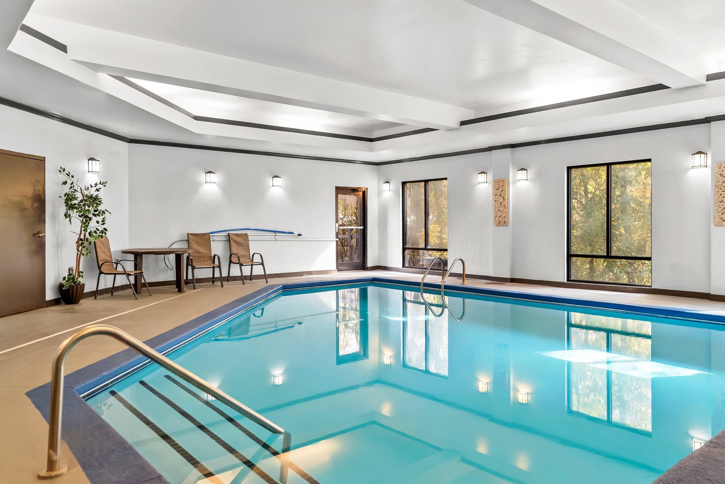 Una piscina techada, sillones reclinables de piscina