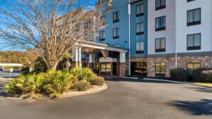 A hotel with a modern design, featuring a prominent crescent moon logo on the facade. - Comfort Suites Simpsonville - Greenville (Simpsonville)