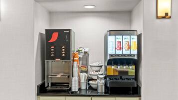A compact coffee station with a coffee machine, a beverage dispenser, and a menu display.