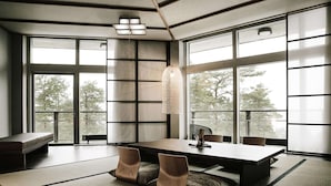 Un comedor moderno con una mesa grande, asientos acolchados y ventanas amplias.