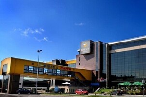 Un edificio moderno con fachada amarilla y un amplio acceso de vidrio.