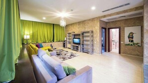 A living room with a sofa, a television, and a green curtain. - Business V Hotel (Tirgu Mures)