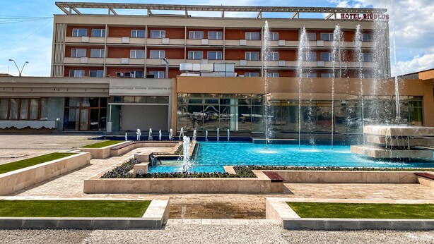 A hotel with a swimming pool and a fountain.