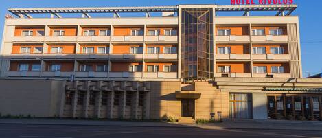 Un hotel de varios pisos con un letrero llamativo que dice "HOTEL RIVULUS".