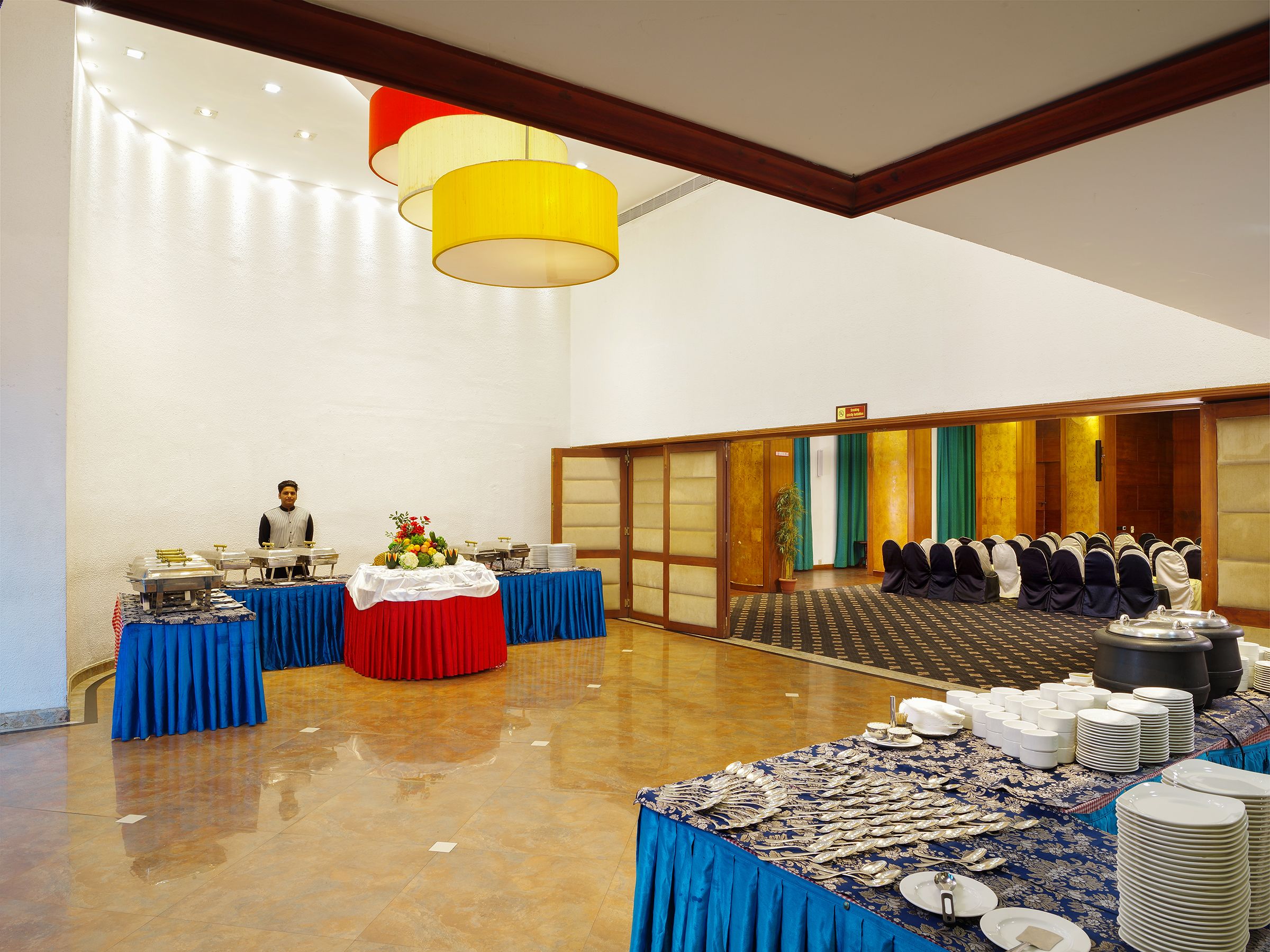 A banquet hall with tables set for a formal event, a buffet area, and a seating area with chairs.
