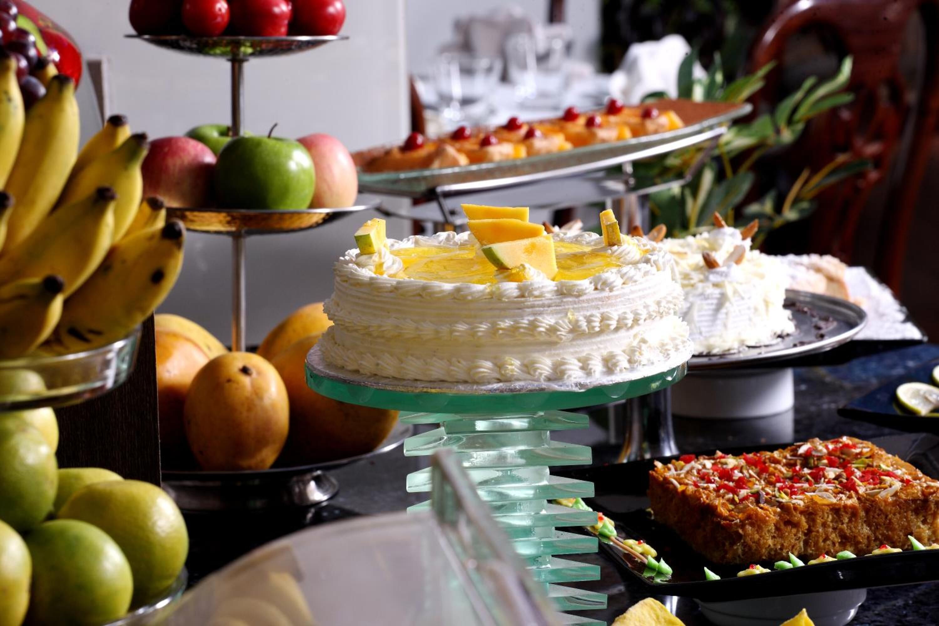 Een buffet met verschillende soorten fruit, gebak en een dessertplateau.