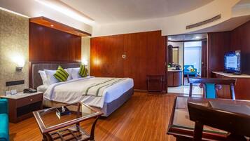 Una habitación de hotel con cama, mesita de noche, lámpara y escritorio con silla.