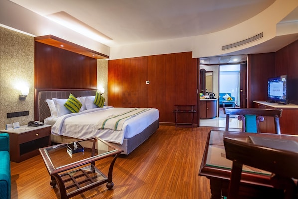 Una habitación de hotel con cama, mesita de noche, lámpara y escritorio con silla.
