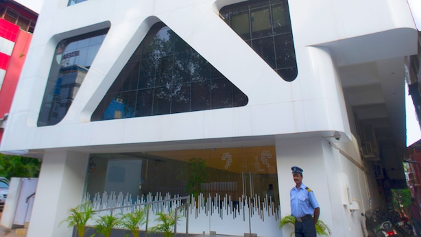 A modern hotel with a unique angular facade and large windows. - Hotel Pankaj (Thiruvananthapuram)