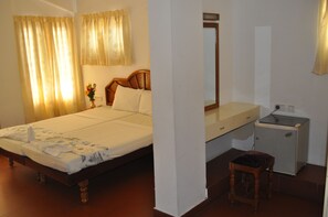 Ein Schlafzimmer mit einem hölzernen Bett, einem Nachttisch, einem kleinen Schreibtisch und einem Stuhl.