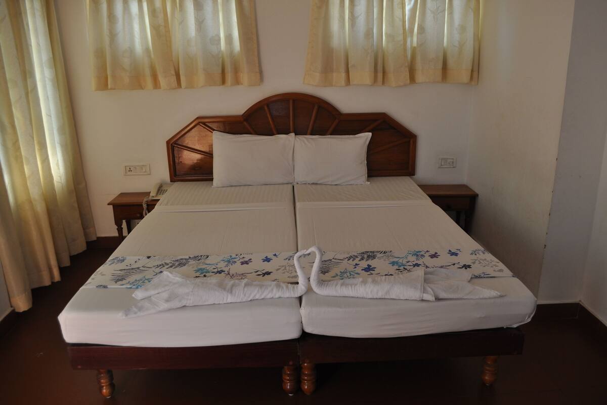 A double bed with a wooden headboard, two bedside tables, and a floral bedspread.