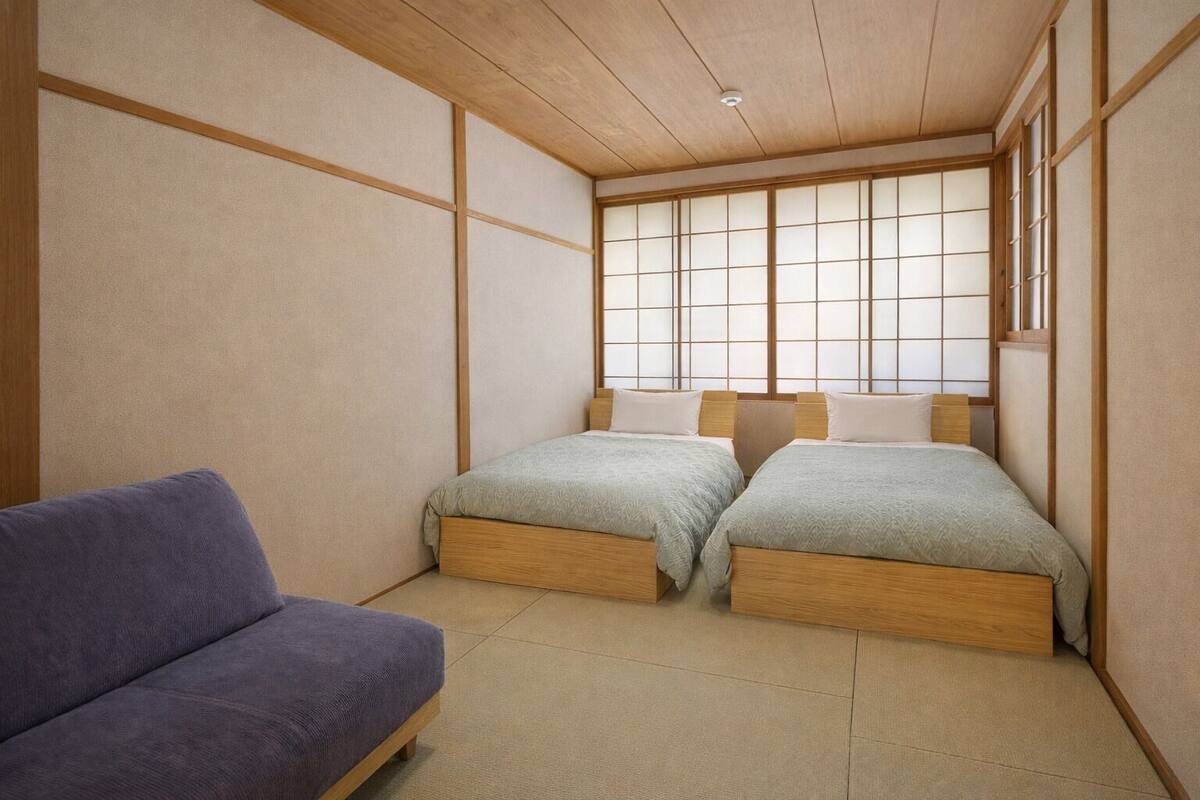 Une pièce de style japonais traditionnel, avec un sol recouvert de tatamis, un plafond bas en bois et des panneaux coulissants en papier de riz (shoji).