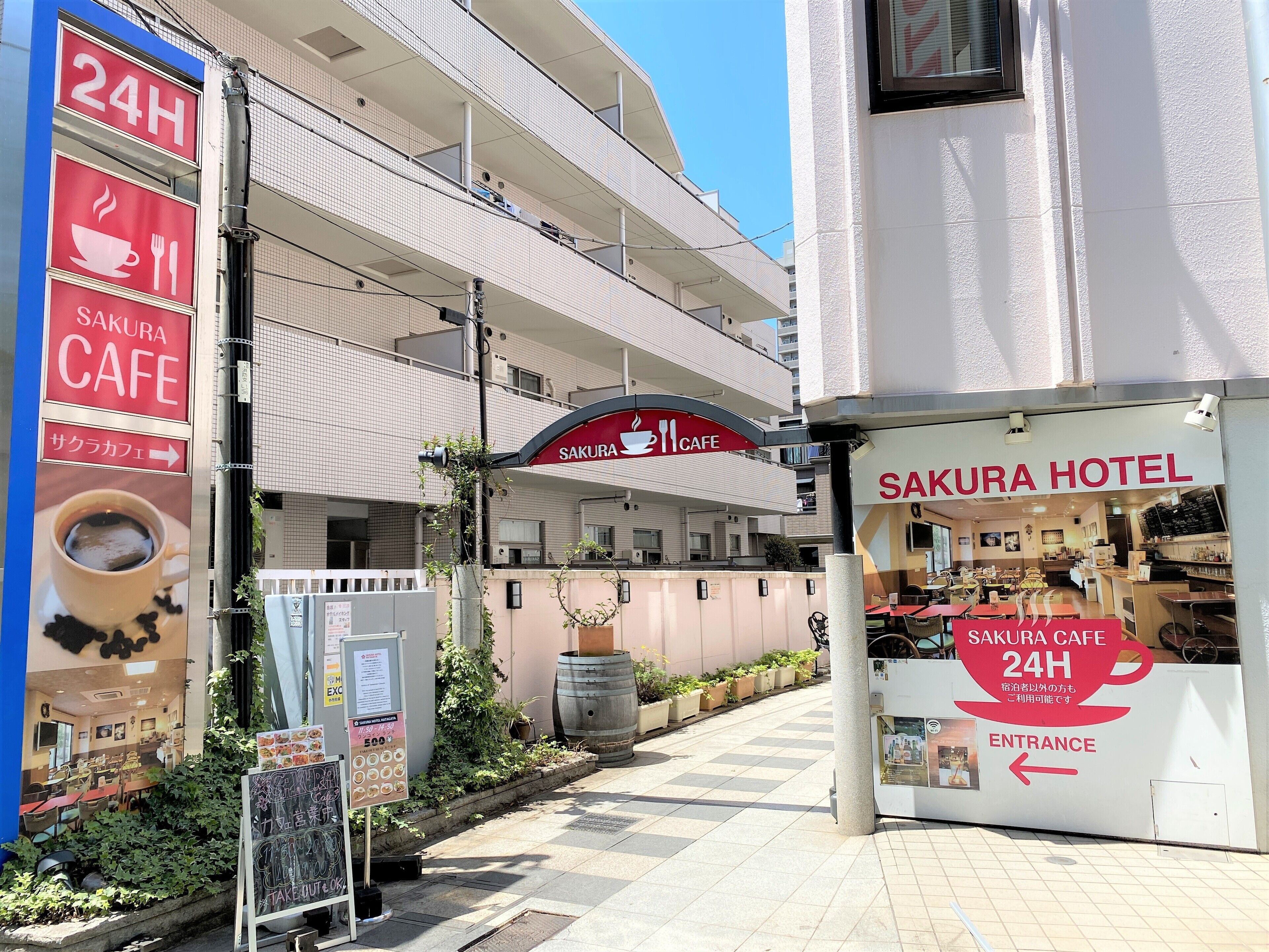 A Sakura Hotel with a 24-hour cafe, a sign indicating Sakura Cafe, and a sign for Sakura Hotel.