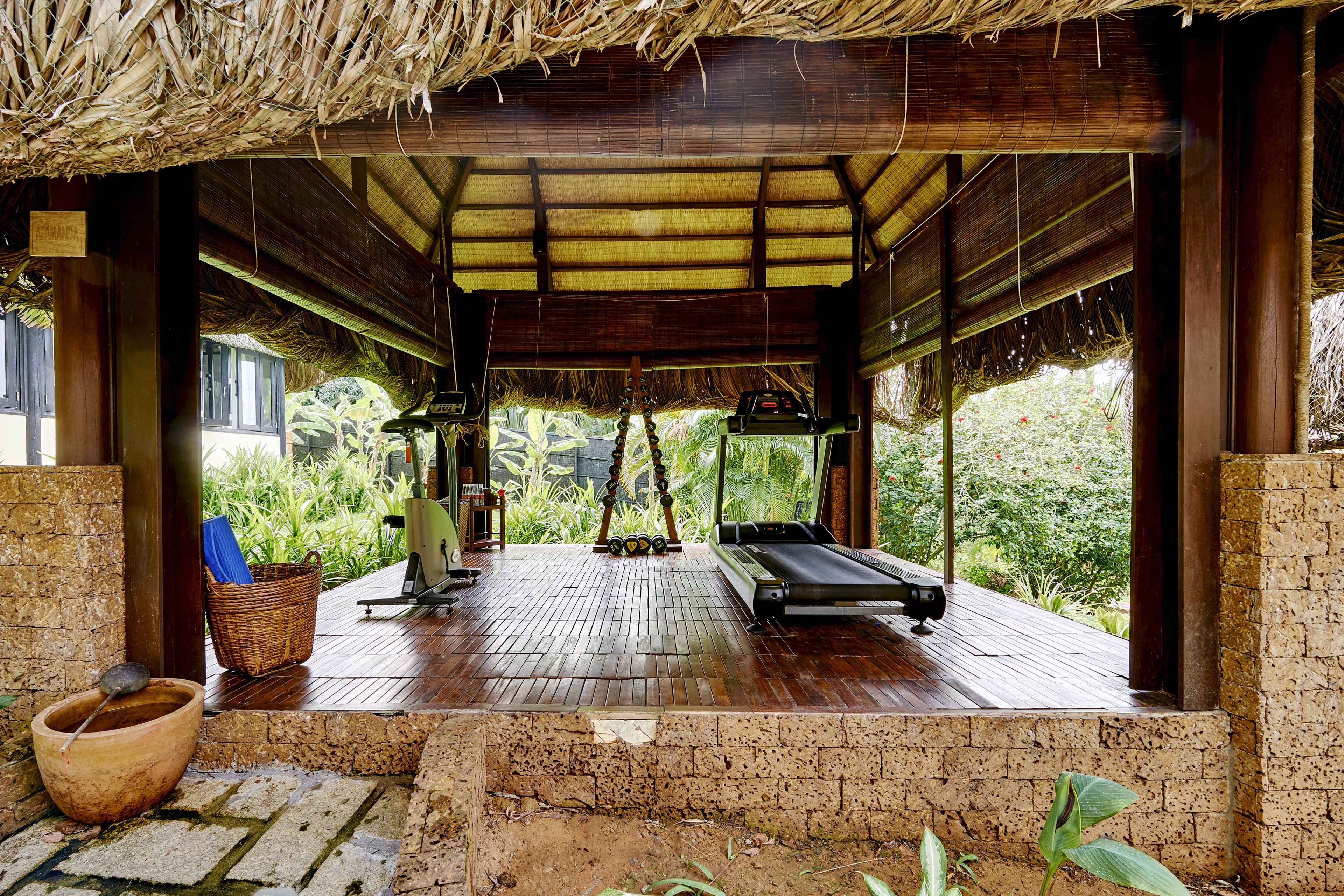 A covered wooden deck with a massage table, a basket, and a bowl.