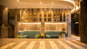 A lobby with a marble floor, a green sofa, and a reception desk. - TSG EMERALD VIEW HOTEL AND SPA (Port Blair)