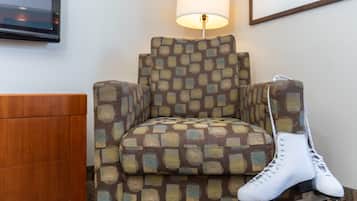 A chair with a patterned fabric and a pair of white roller skates placed on it.