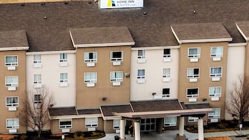 A multi-story hotel with a sign reading "HOME INN & SUITES by dhah".