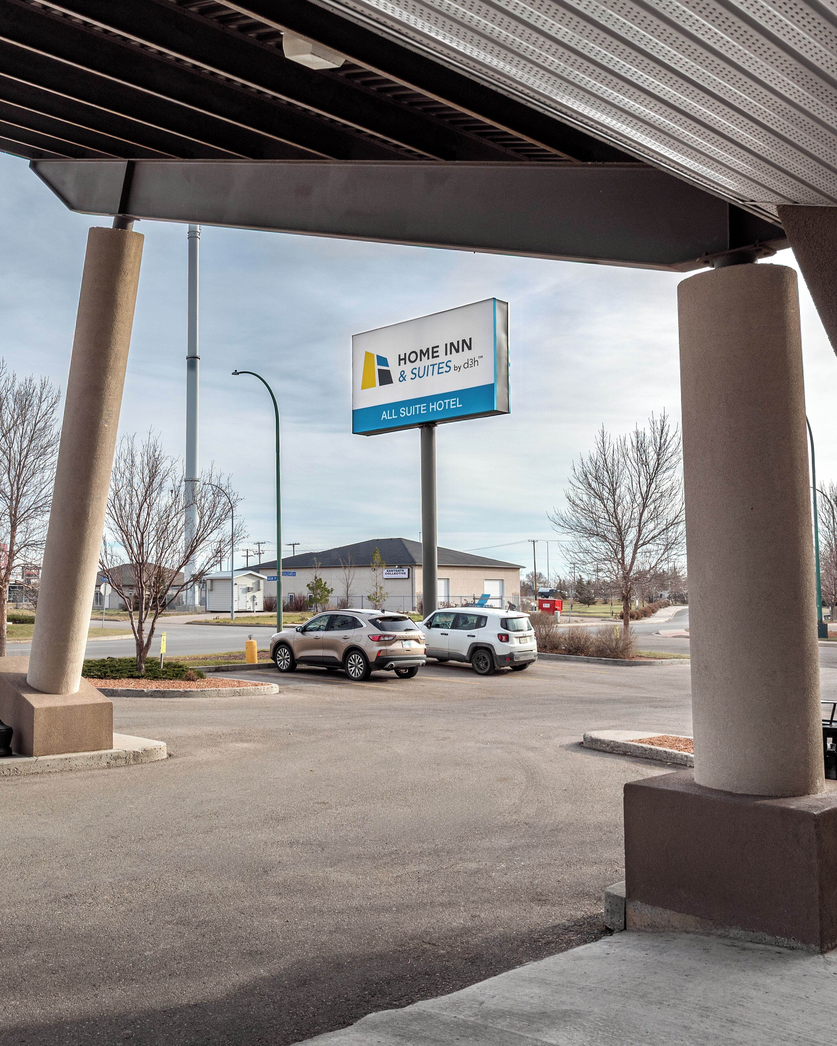 A parking lot with a sign for Home Inn & Suites by D3H™ All Suite Hotel.