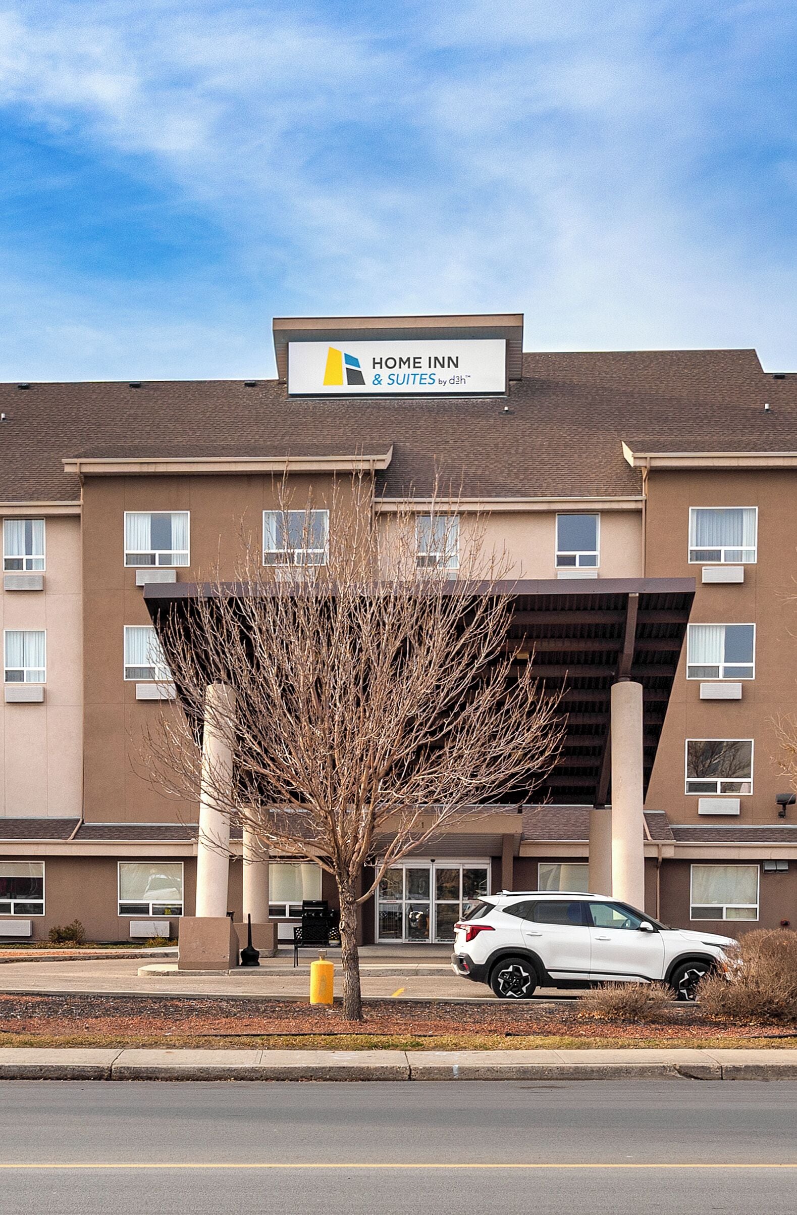 A building with a sign reading "Home Inn & Suites by Dhl".